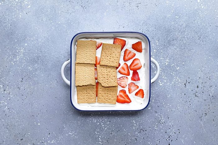 Crackers strawberries and cream mixture in a large pan