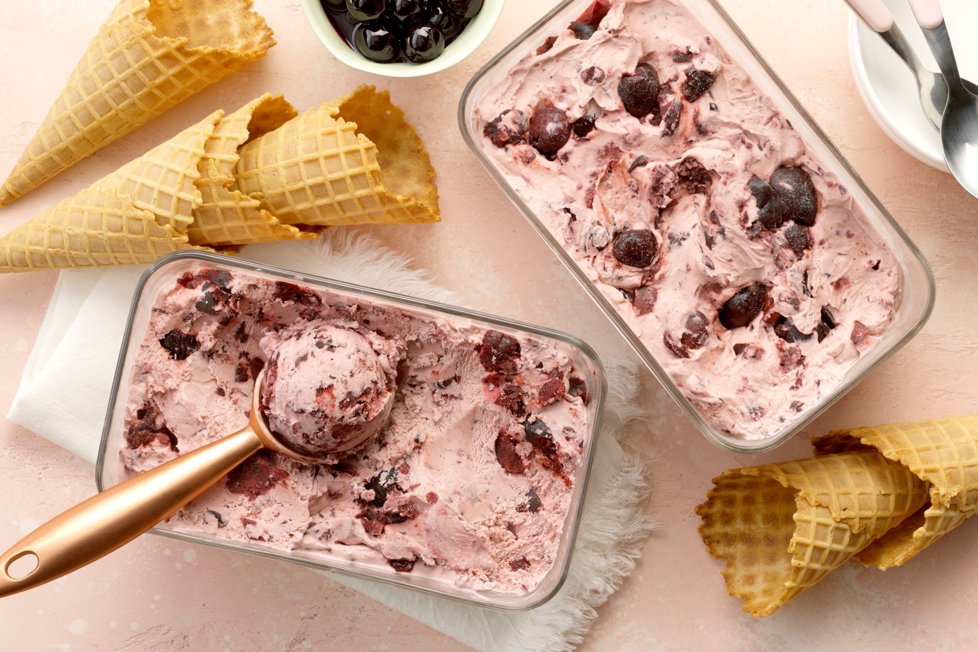 Two containers of Cherry Nut Ice Cream with cherries and chocolate toppings