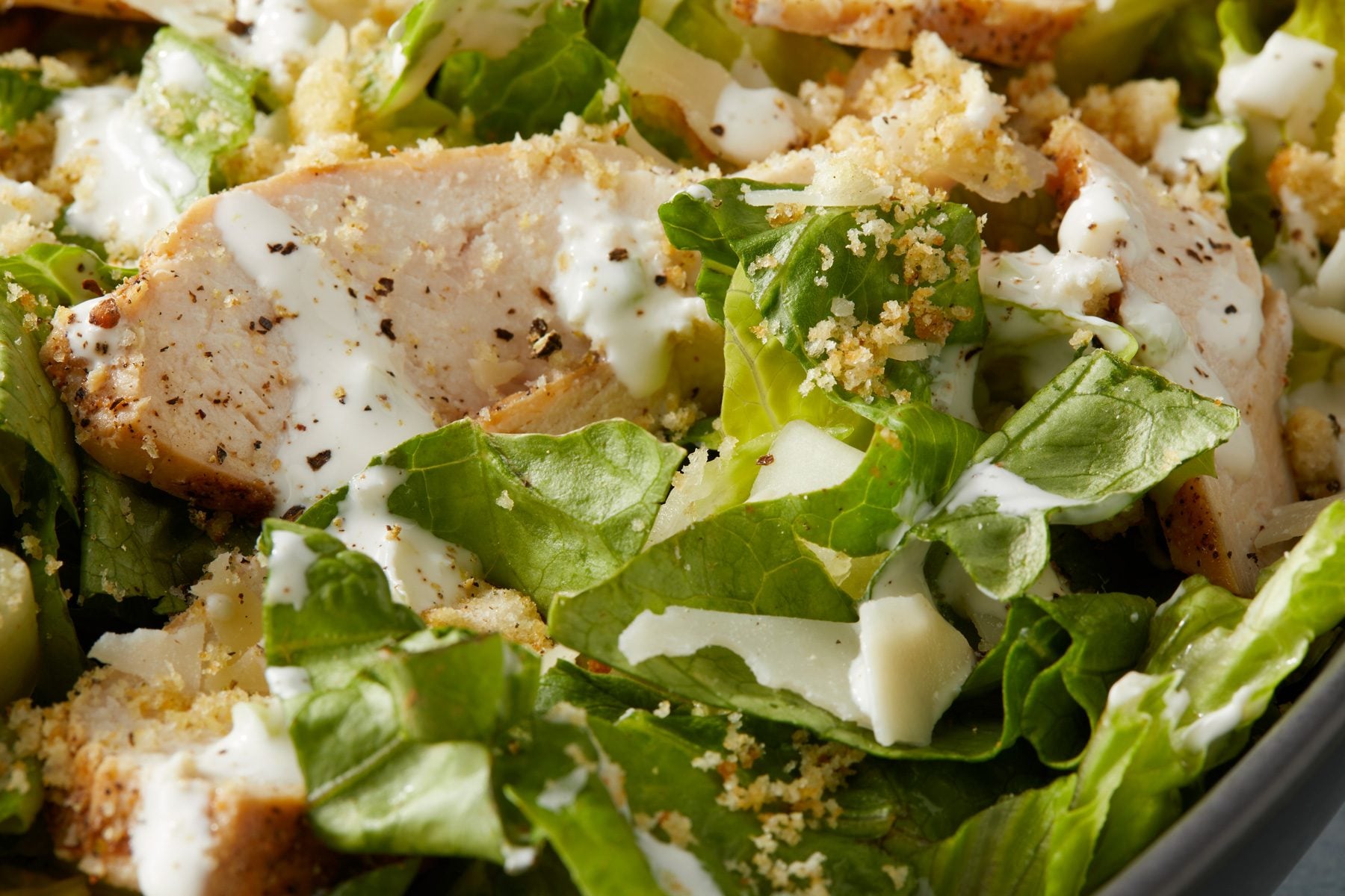 A bowl of Creamy Garlic Salad Dressing on a table.