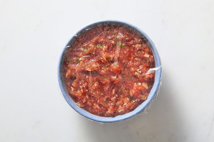 Covering the salsa to chill in the fridge