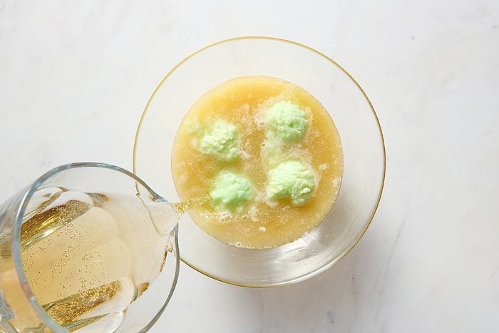 Combining the lime sherbet punch ingredients in a large bowl