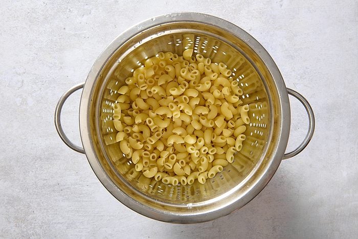 Cooked macaroni draining in a colander
