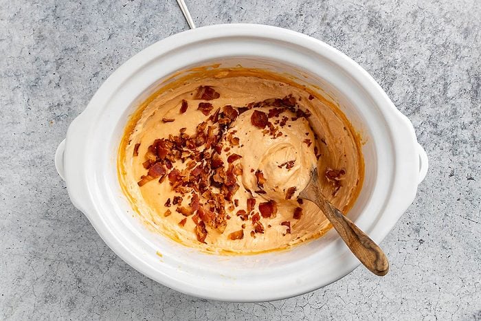 Taste of Home Bacon Dip recipe photo of the bacon crumbles stirred into the cheese sauce.