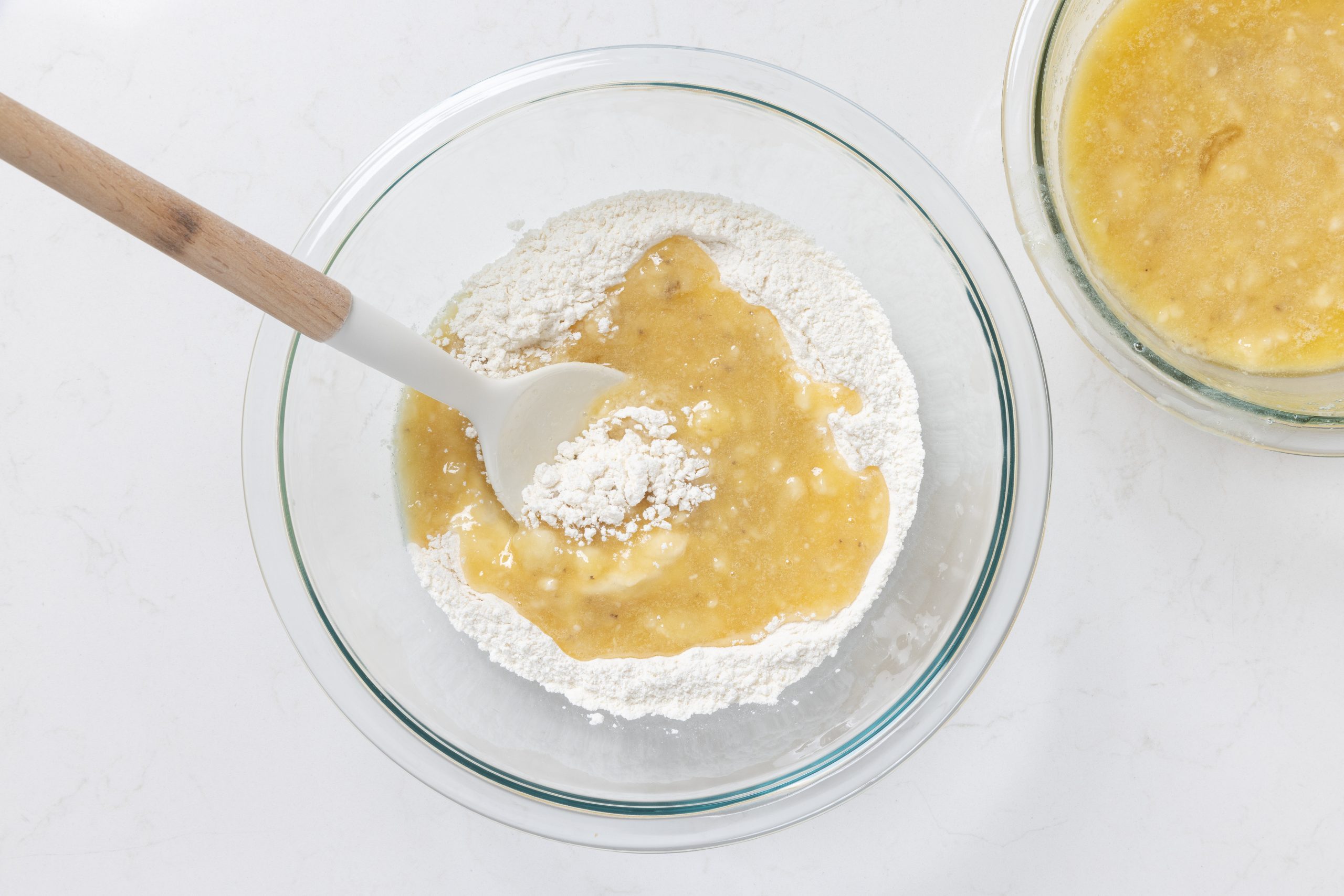 Wet ingredients and dry ingredients being combined in mixing bowl.