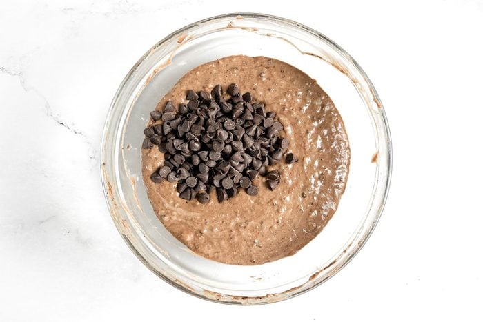 Batter for Taste of Home Chocolate Banana Muffins in a glass bowl on a marble surface