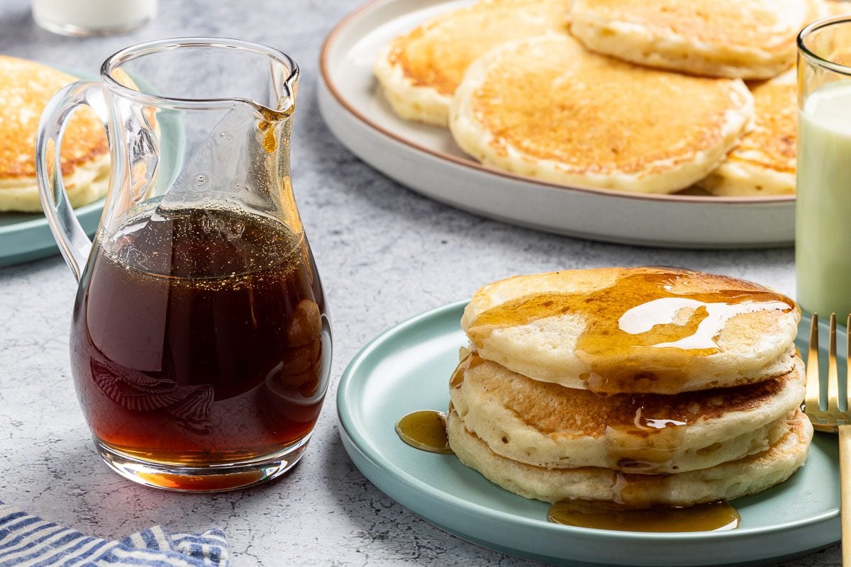 wide shot of Homemade Pancake Syrup with pancakes.