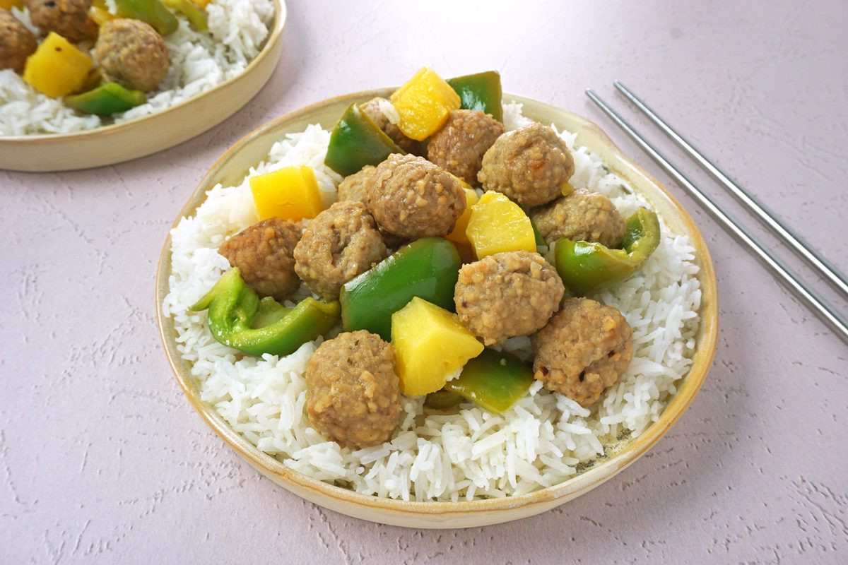 Two plates of slow cooker sweet and sour meatballs with rice and chopsticks for Taste of Home RMS 27421