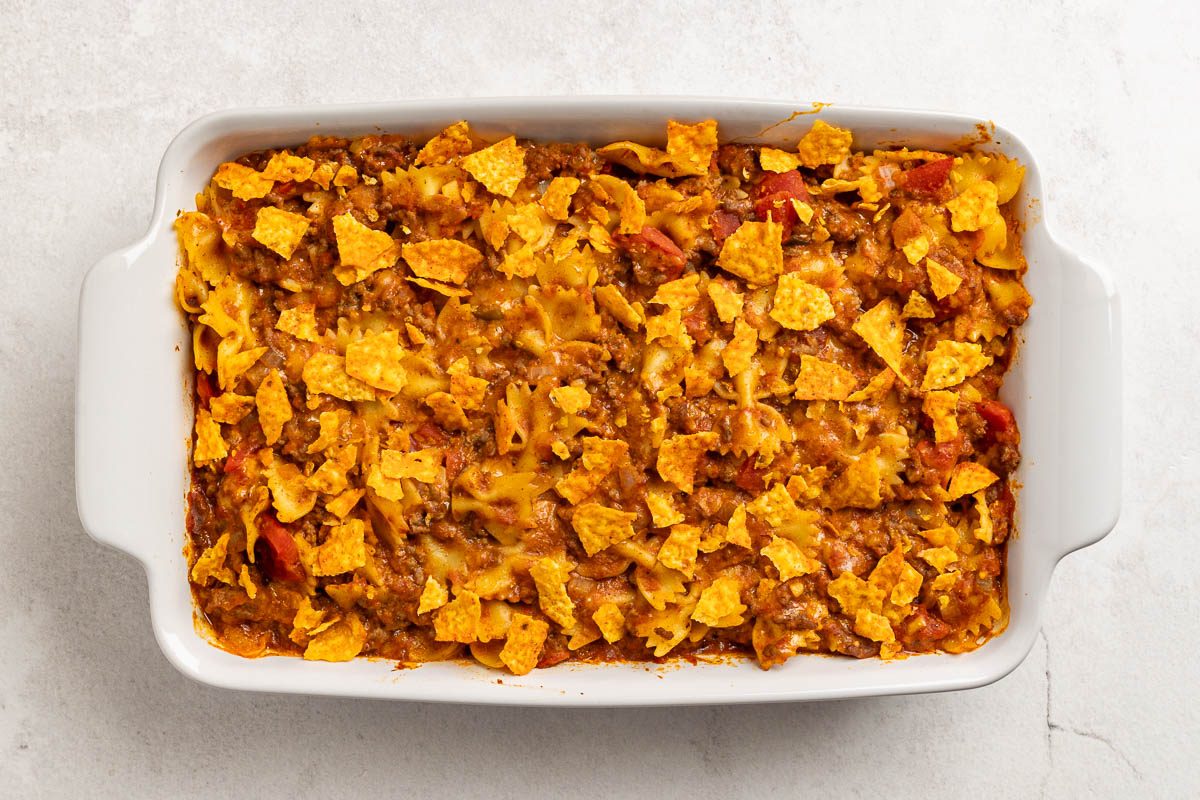 overhead shot of baked taco pasta casserole sprinkled with tortilla chips