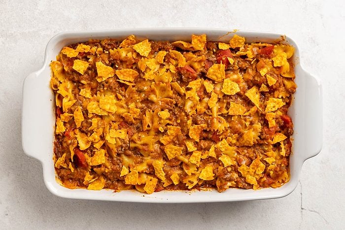 overhead shot of baked taco pasta casserole sprinkled with tortilla chips