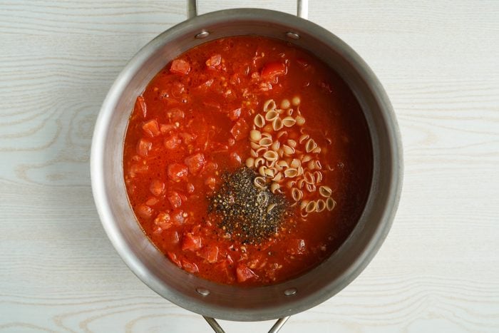 Adding pasta to Tomato Florentine Soup