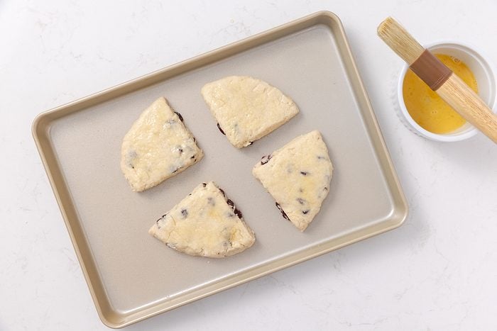 Scones in baking sheet after being brushed with egg and coarse sugar.