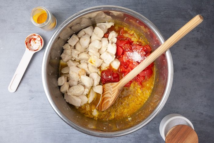 Step 2 of Taste of Home Instant Pot Chicken Curry is to Add the onion, curry, turmeric and cumin. Cook and stir until the onion is tender, which takes three to five minutes. Next, add the broth, stirring to loosen browned bits from pan. Then, stir in the tomatoes, tomato paste, garlic, ginger, sugar, chicken and salt.