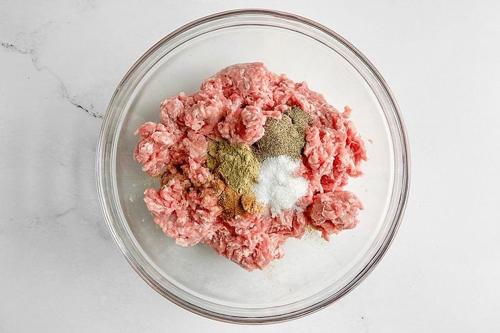 Ingredients for Taste of Home Sausage Patties in a glass bowl on a marble surface