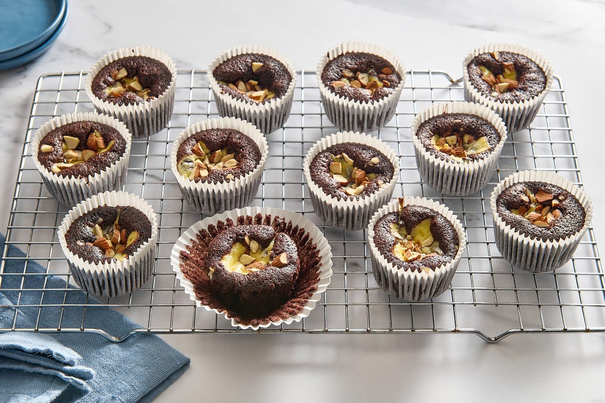 Angled shot of several black bottom cupcakes on a wire rack