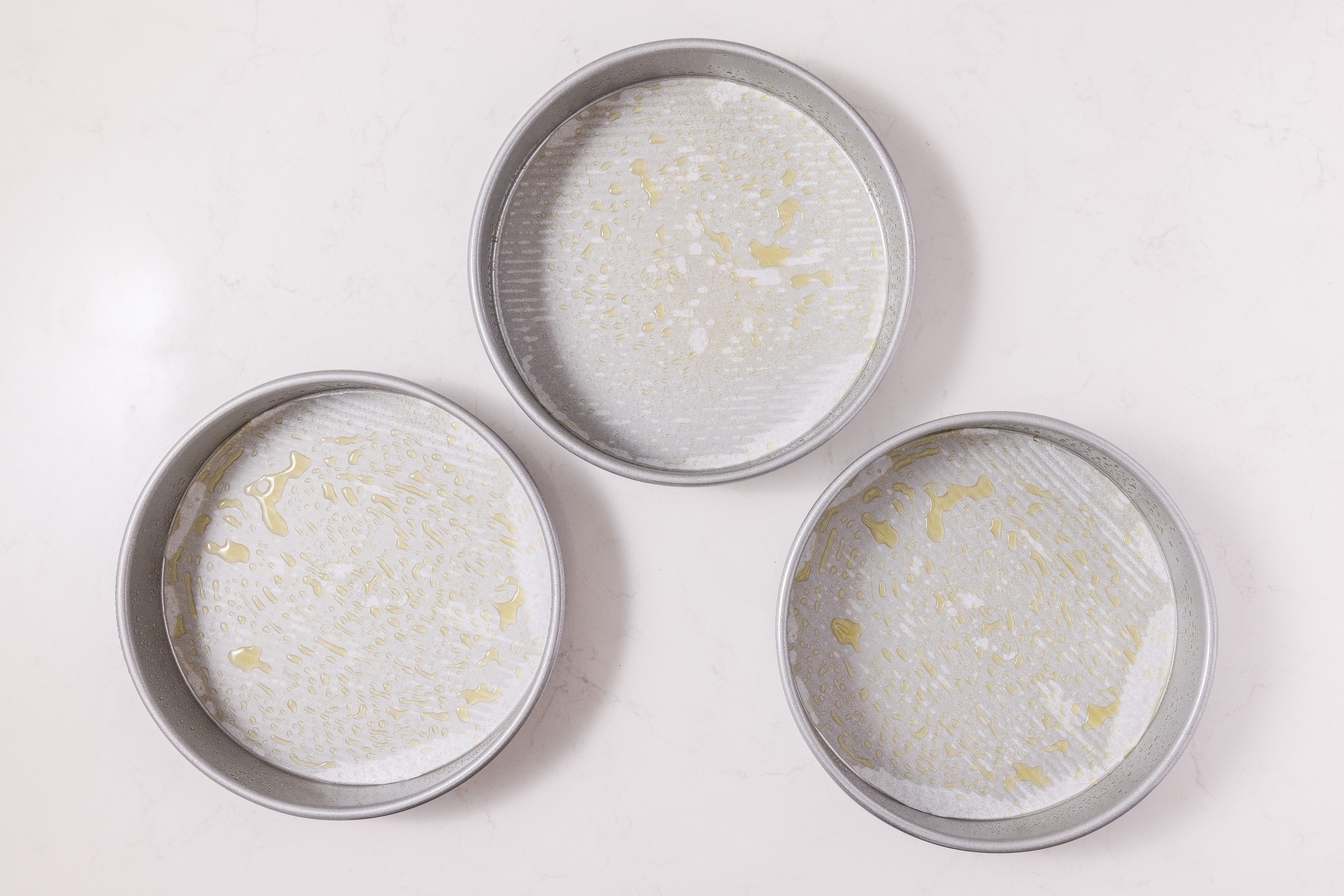 Greased cake pans on kitchen counter.