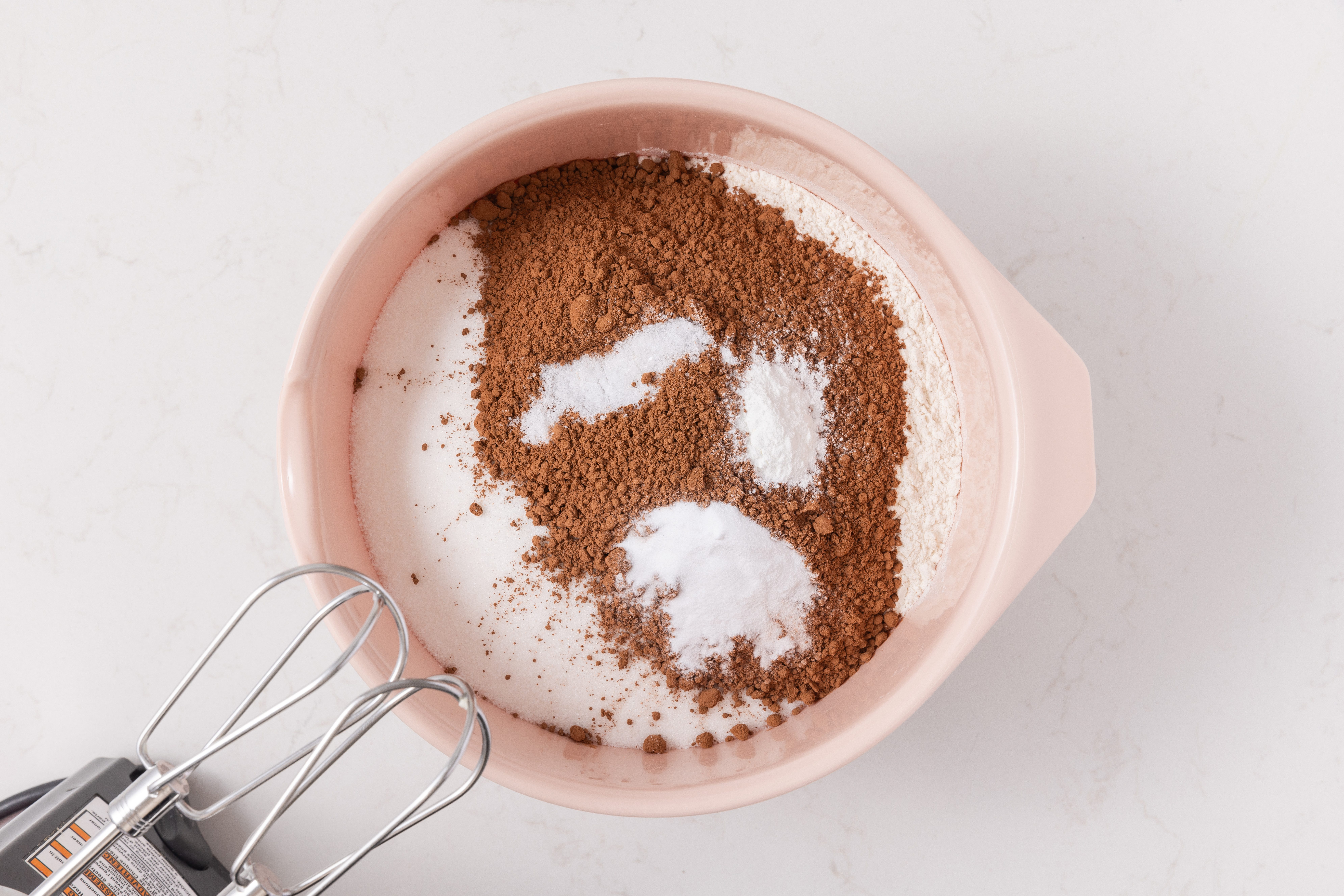Dry ingredients for cake base being combined in mixing bowl.