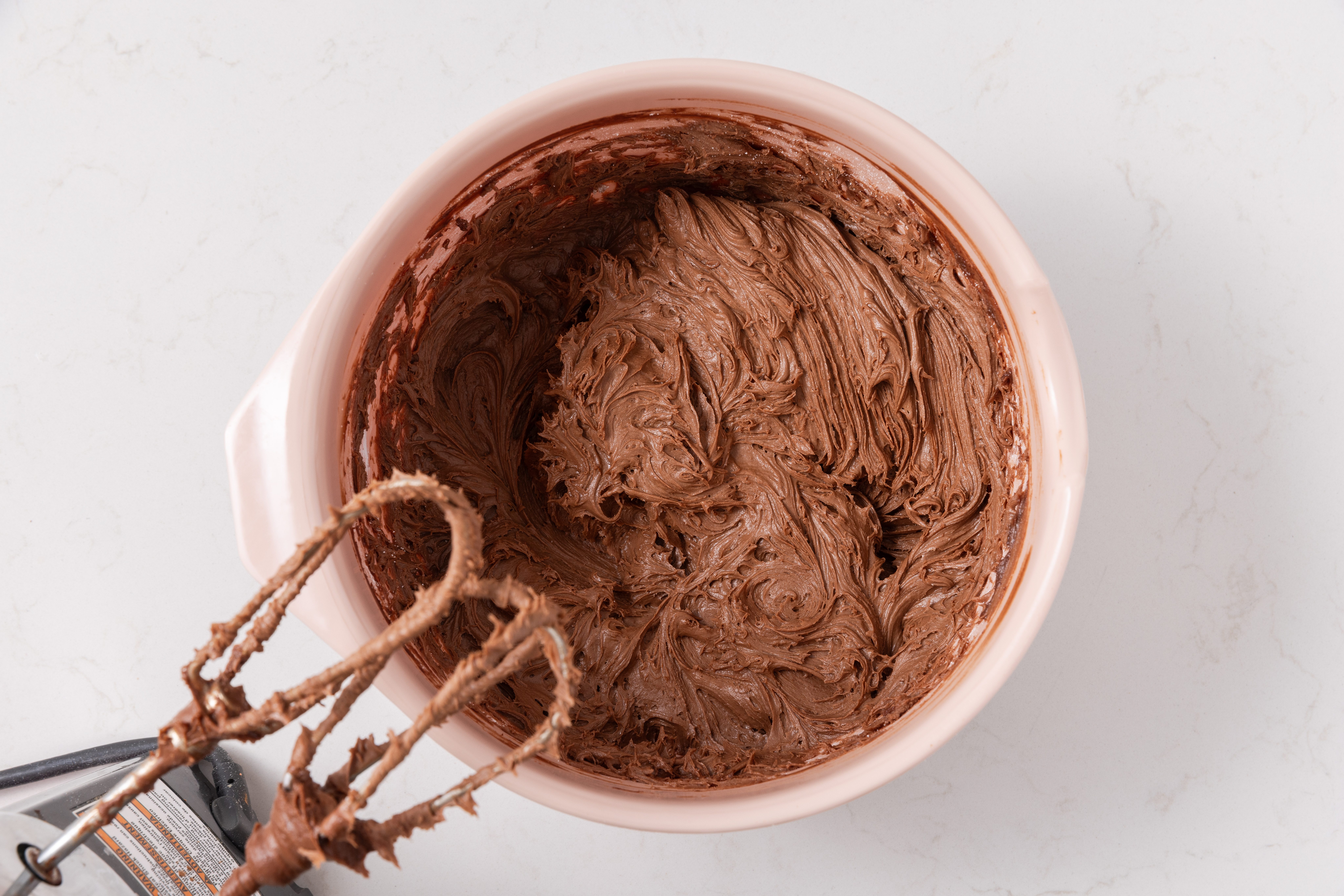 Frosting being prepared in mixing bowl.