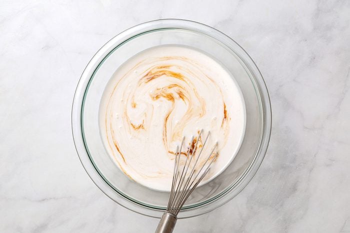Coconut cream, coconut milk, maple syrup and vanilla being mixed in a bowl for Coconut Popsicles for Taste of Home