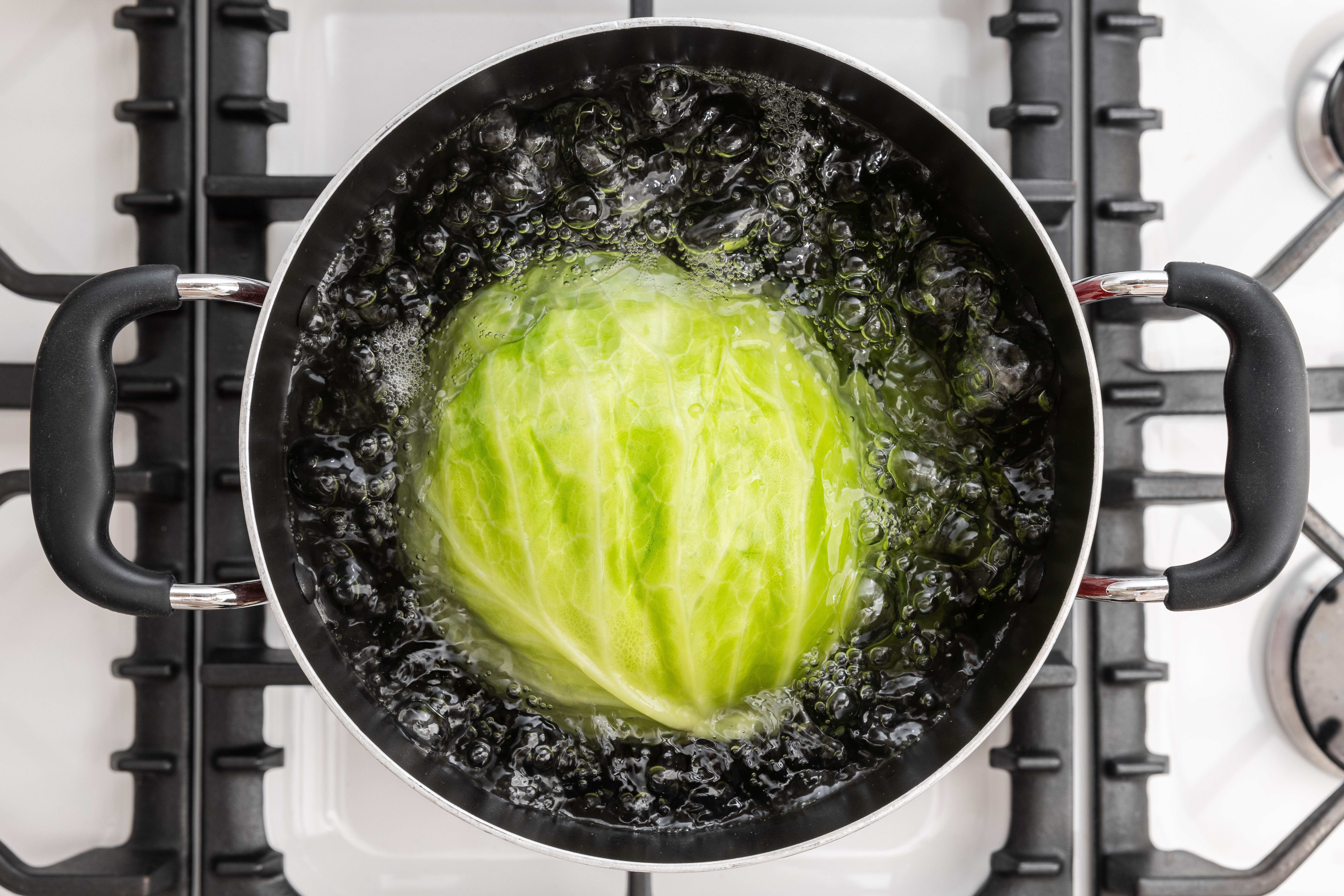 Cabbage being boiled in pot.