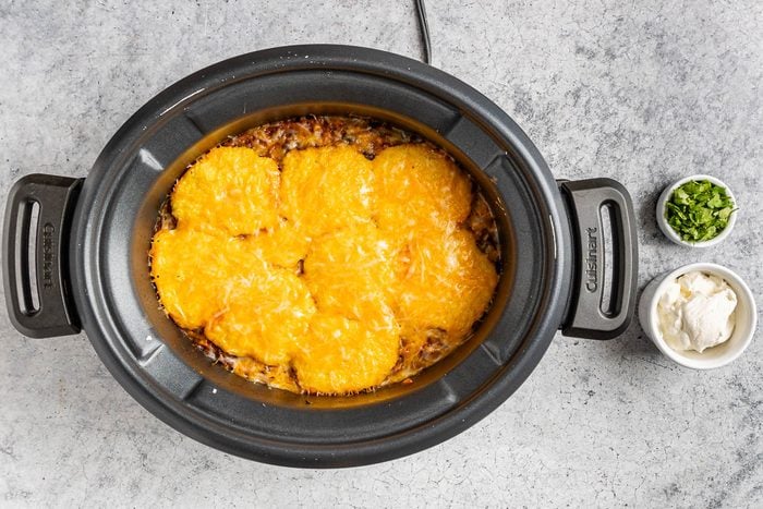 Taste of Home Crockpot Tamale Pie photo of topping the ingredients with cheese.