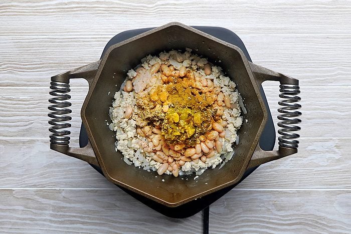 Stir mashed beans, remaining can of beans, chiles, seasonings and broth into chicken mixture