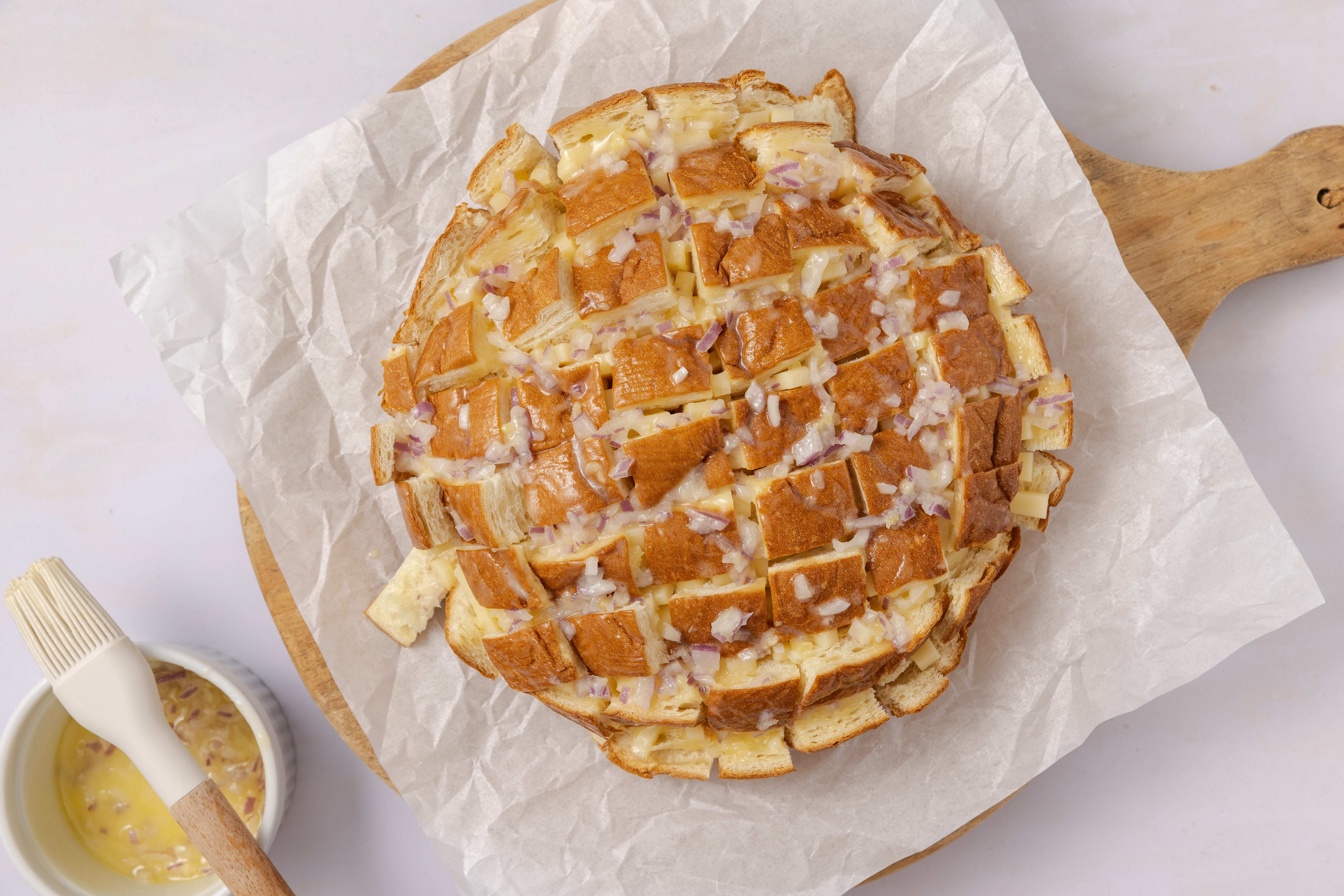 Hawaiian sweet bread filled with cheese and beign brushed with garlic and onions butter.