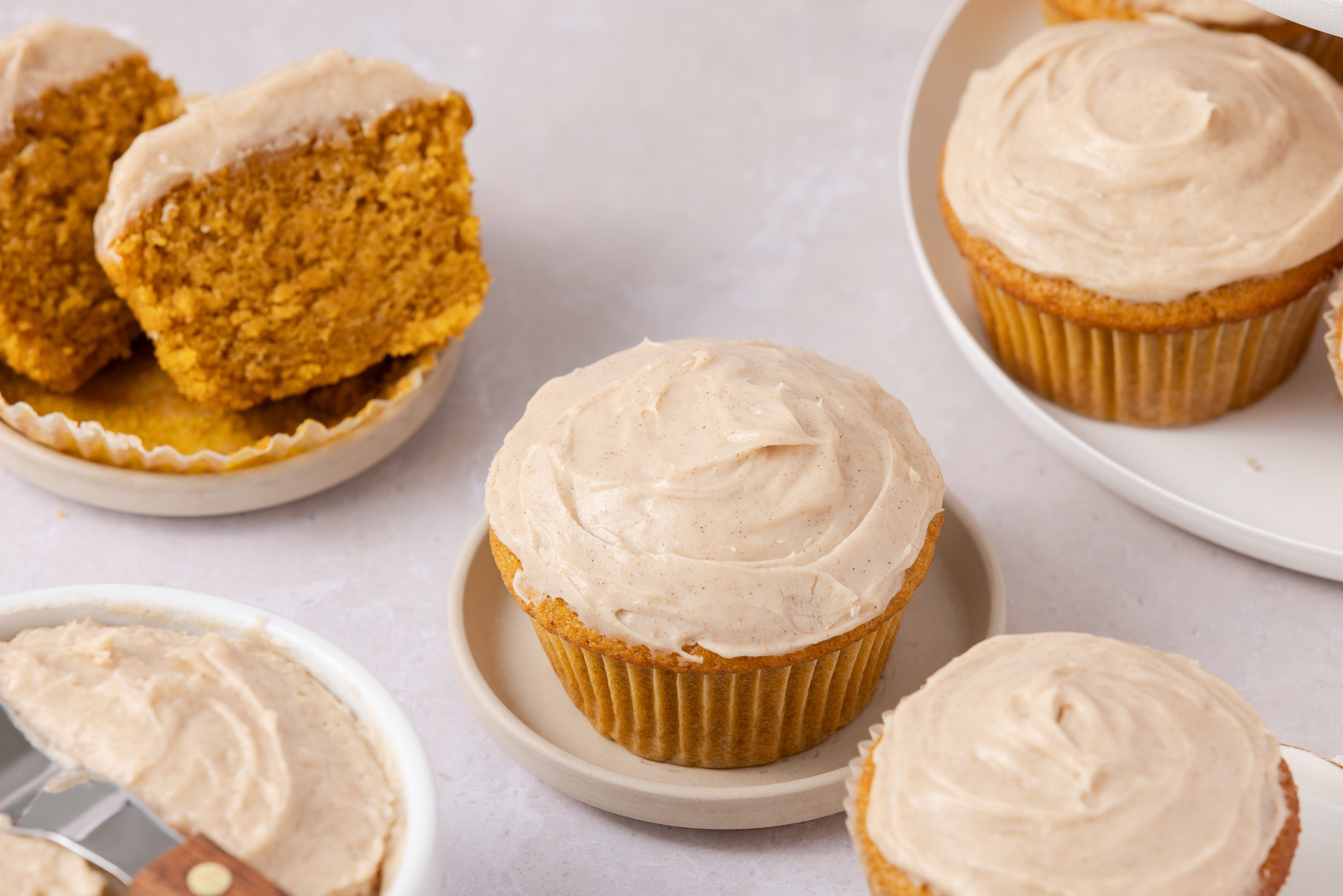 Pumpkin cupcakes served in small plates and on cupcake stand.