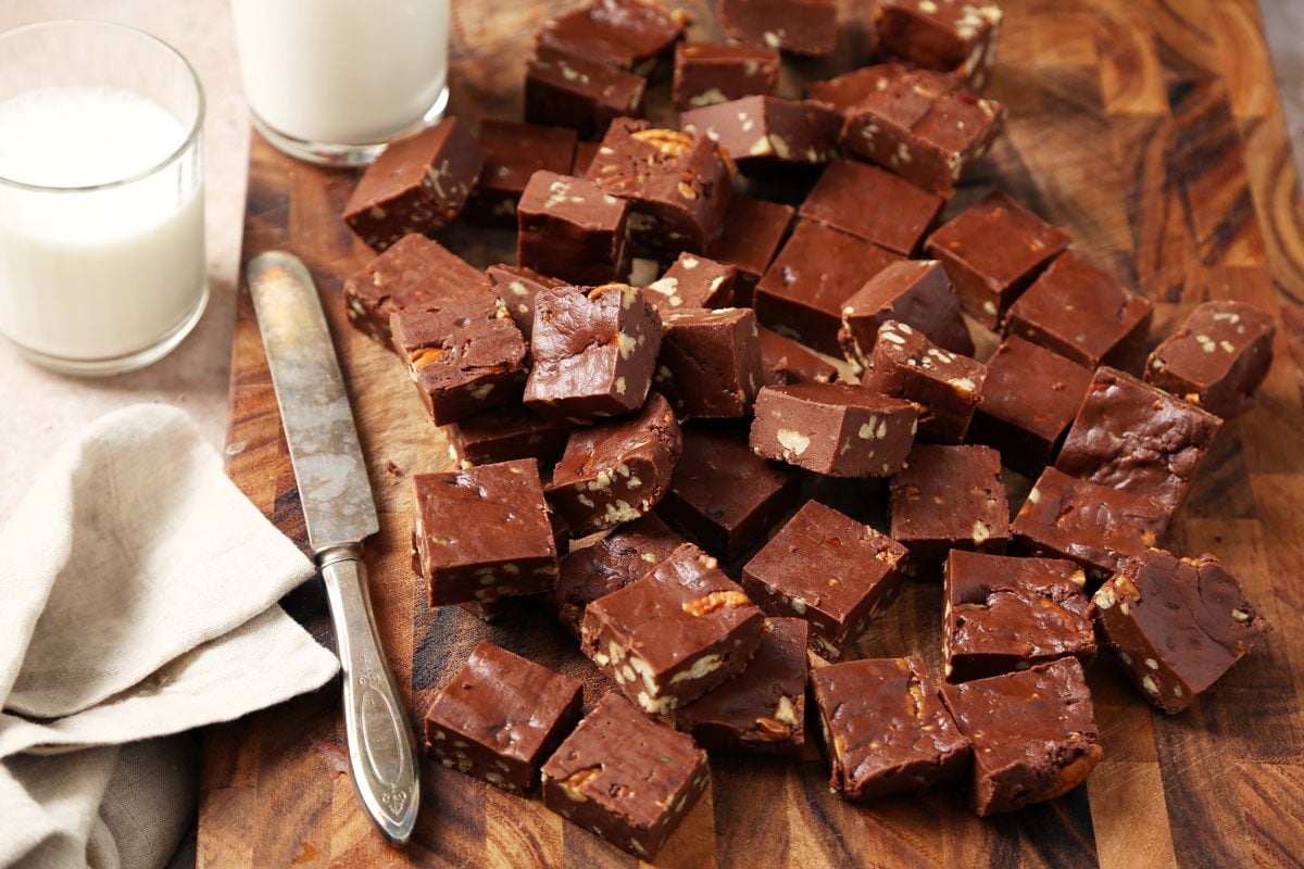 Close up of Taste of Home's Velveeta Fudge sliced on a cutting board on a brown marble surface.