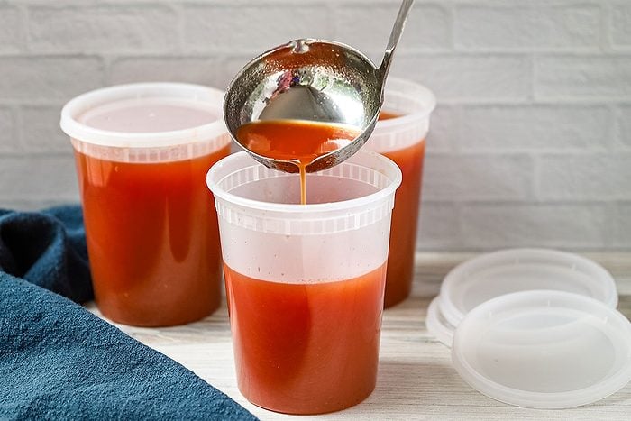 Pouring homemade spicy tomato juice into 1-quart containers, a recipe from Taste of Home.