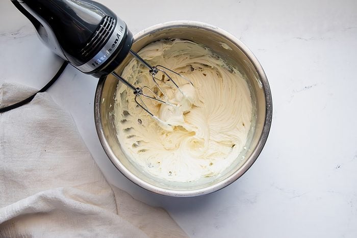 Overhead shot for Taste of Home White Chocolate Ganache, white chocolate and heavy cream being whipped together after cooling slightly.