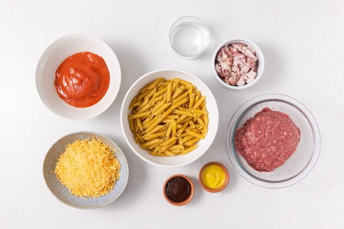 Ingredients for bacon cheeseburger pasta on kitchen counter.