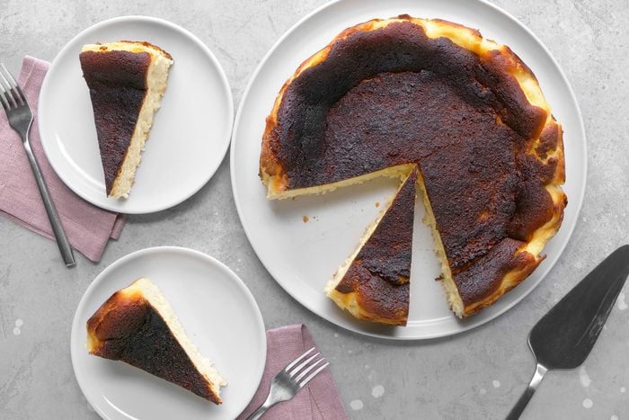 Overhead shot of a perfectly baked Basque cheesecake, highlighting its caramelized top and rustic, slightly cracked edges.