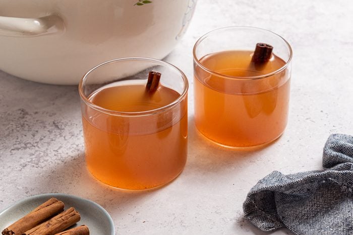 Spiced Apple Cider Inside Glasses With Cinnamon Sticks