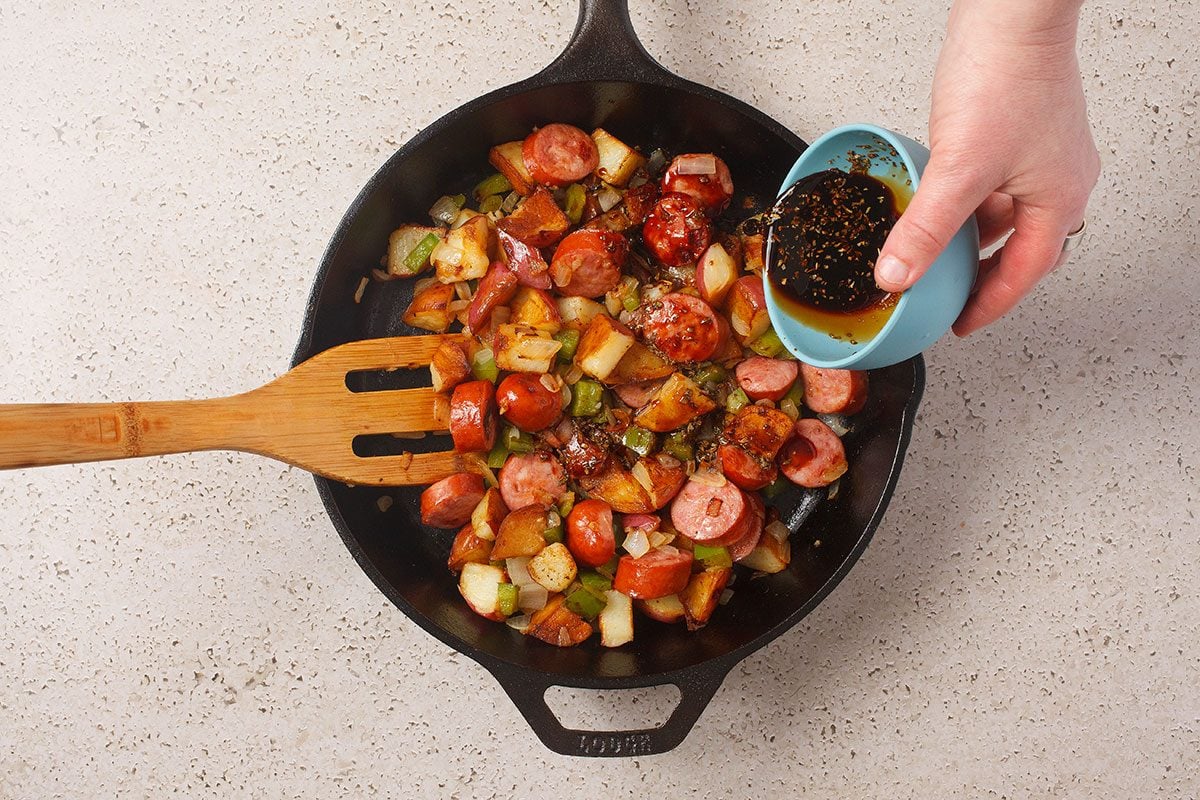 Brats And Potatoes And Veggies Cooking In Skillet