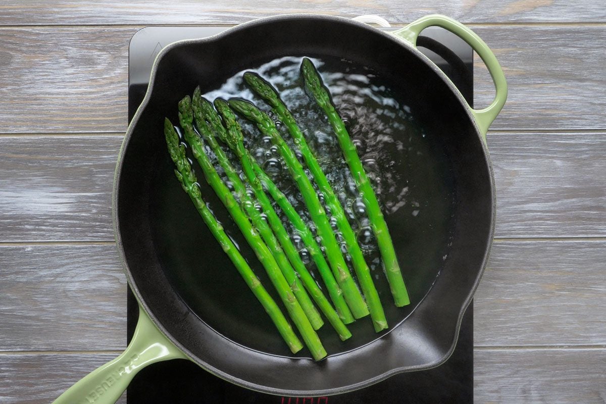In a large skillet boil asparagus