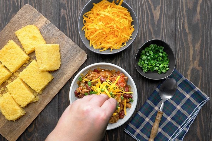 chill being topped with cheese and green onions