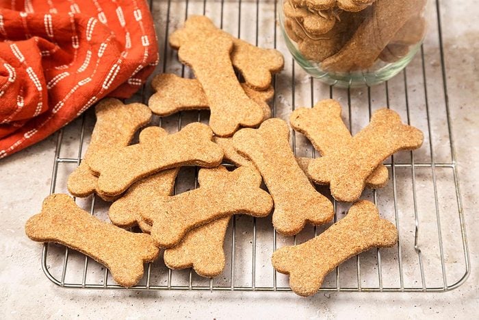 Homemade peanut butter dog treats cooling on a wire rack.