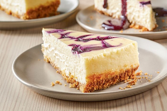 Close shot of Contest-Winning Blueberry Swirl Cheesecake; cut into slices and served on plates