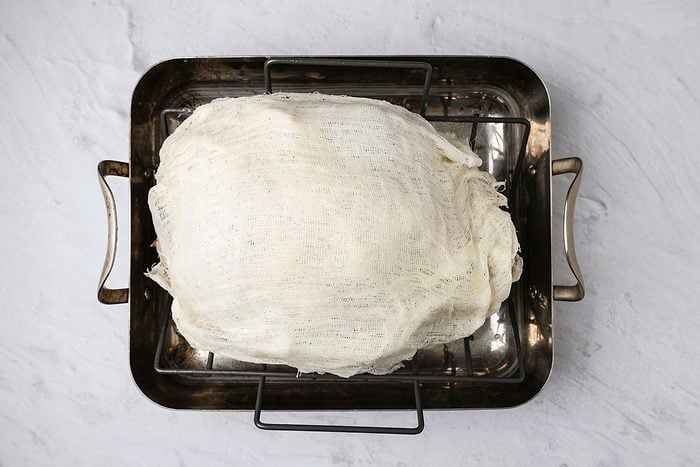 Overhead shot; In a large saucepan melt cubed butter; stir in wine; Saturate a four-layered 17-inch square of cheesecloth in butter mixture; drape over turkey; Bake turkey; uncovered 3 hours; baste with wine mixture every 30 minutes; keeping cheesecloth moist at all times; marble surface;