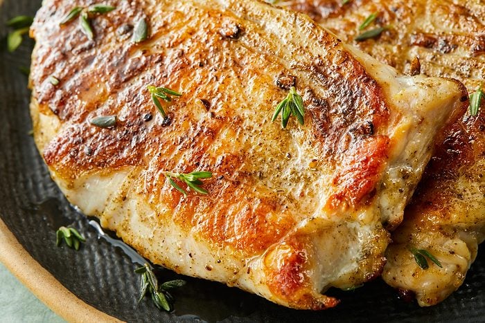 Close-up shot of Turkey Cutlets with Pan Gravy; served on a large platter; on a light green surface;
