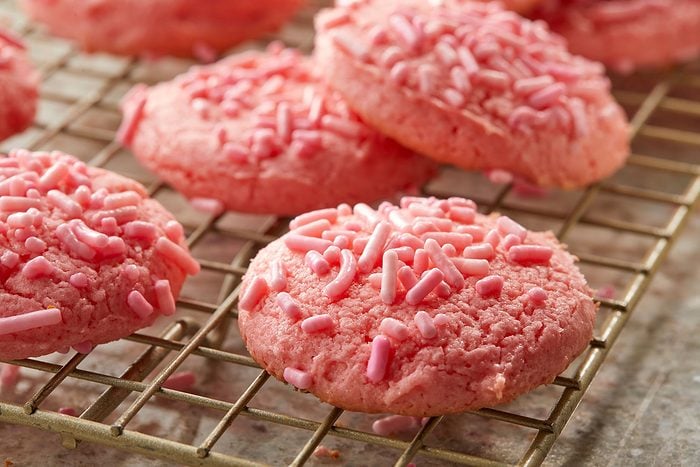 Close-up shot of Strawberry Cake Mix Cookies; served over wire rack on a marble surface