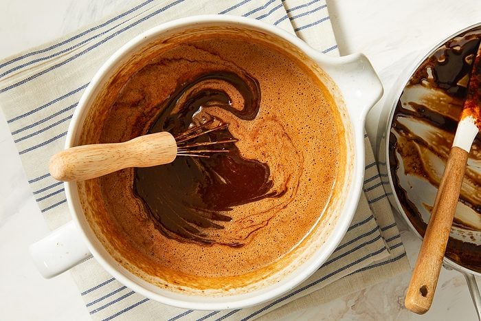 chocolate mixture added to eggs in a large bowl