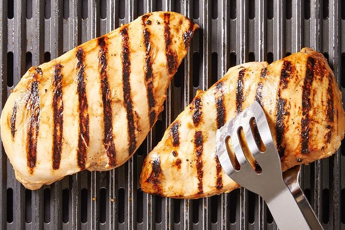 Grill chicken, covered, on a greased grill rack