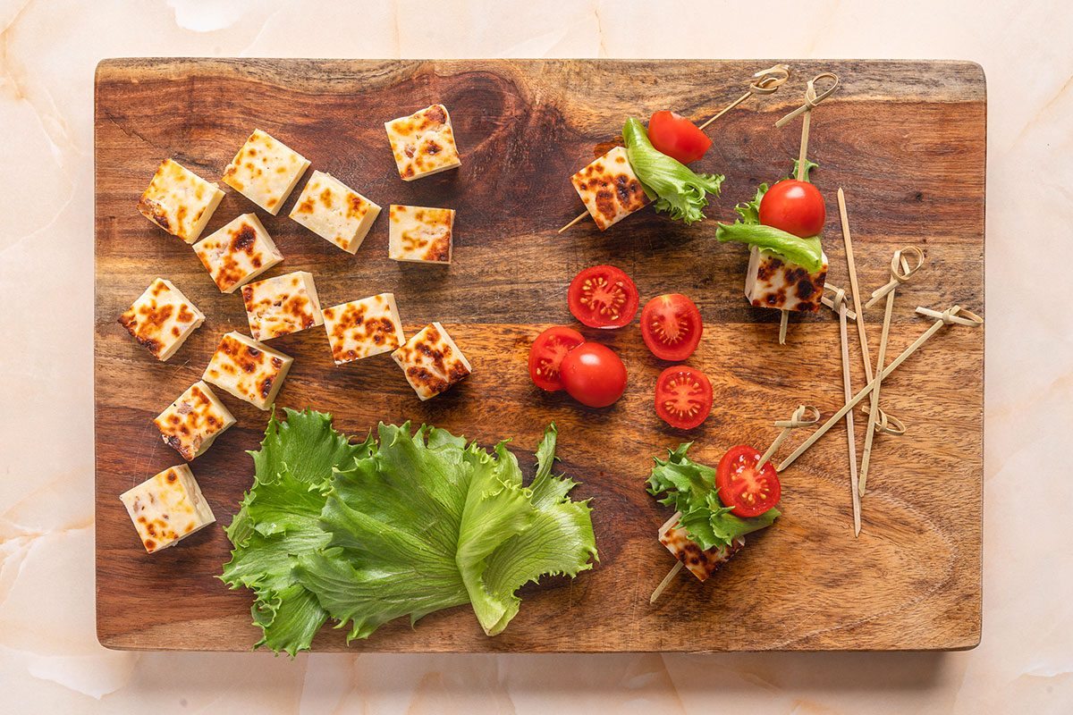 Cut the bacon bread cheese into cubes. Slice the cherry tomatoes in half and tear off bite-sized pieces of lettuce.