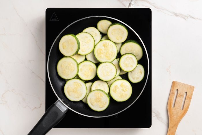 In a large enamel-coated cast-iron or other heavy skillet, heat oil over medium-high heat. Add zucchini