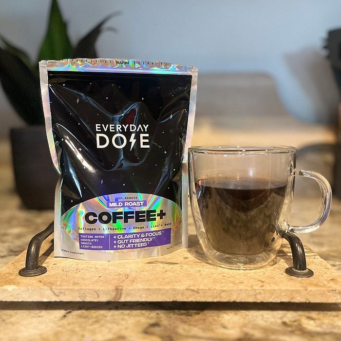 A bag of Every Dose coffee next to a filled coffee mug