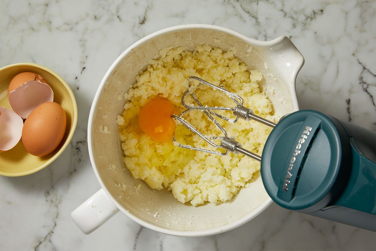 Beating up eggs and flour to makeYellow Squash Cake in a bowl