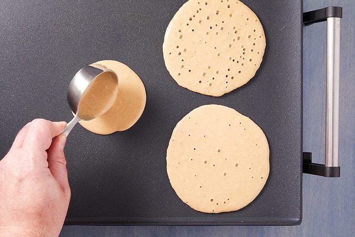pancake batter poured onto a greased, hot griddle