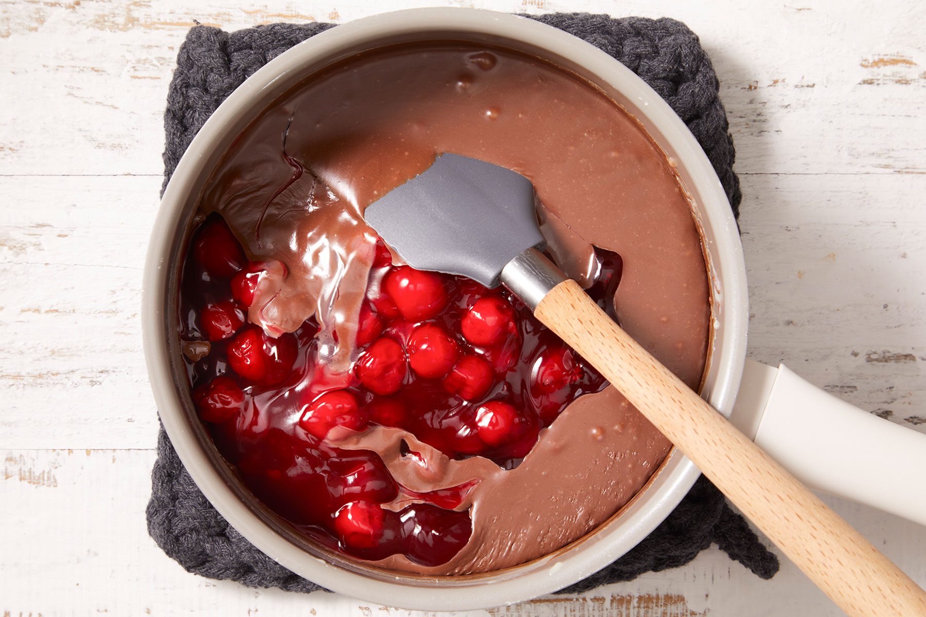 Pouring pie filling in the melted chocolate in a saucepan and cooking.