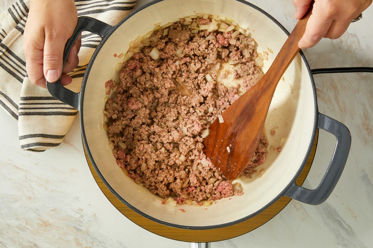 ground beef being cooked in a dutch oven